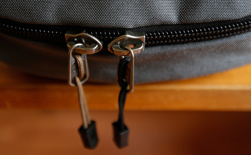 visible variant TB0512A-CA TB0512A-BA^^Cord Zipper Pulls with plastic pull tabs attached to a bag's metal pull tabs.