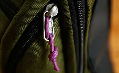 visible variant TB0512B-UA^^Cord Zipper Pulls knotted and attached to a bag's metal zipper tabs