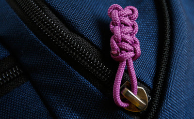 visible variant TB0512C-UA^^Cord Zipper Pulls knotted and attached to a bag's zipper sliders directly