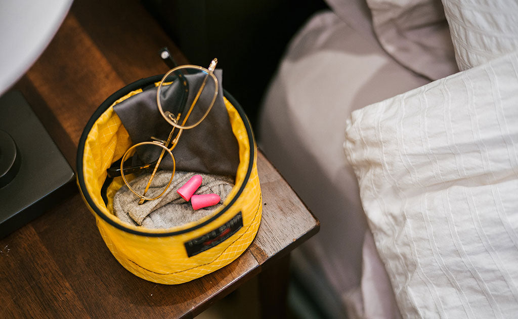 Lifestyle visible^^A Large Travel Tray holding an eyeglass cleaning rag, glasses, earplugs, and a handtowel.