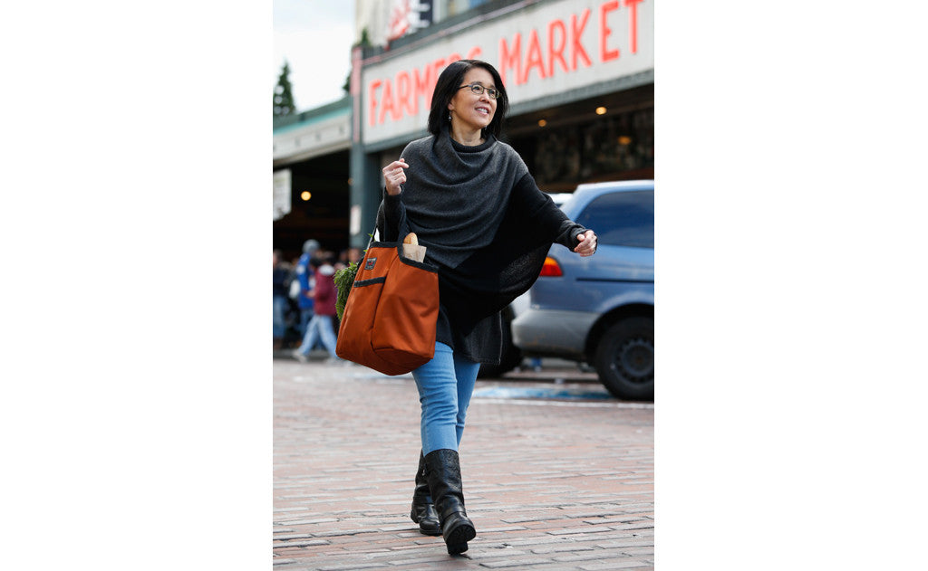 lifestyle visible^^A person carrying a filled Moveable Feast away from Pike Place Market.