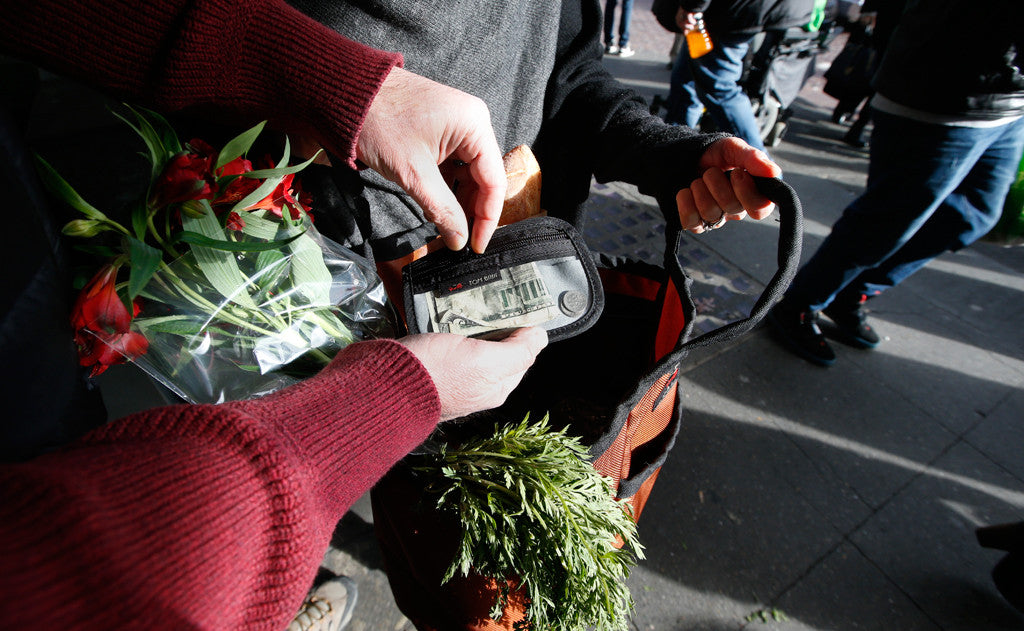 lifestyle visible^^A person holding a Moveable Feast while accessing a Clear Organizer Wallet.