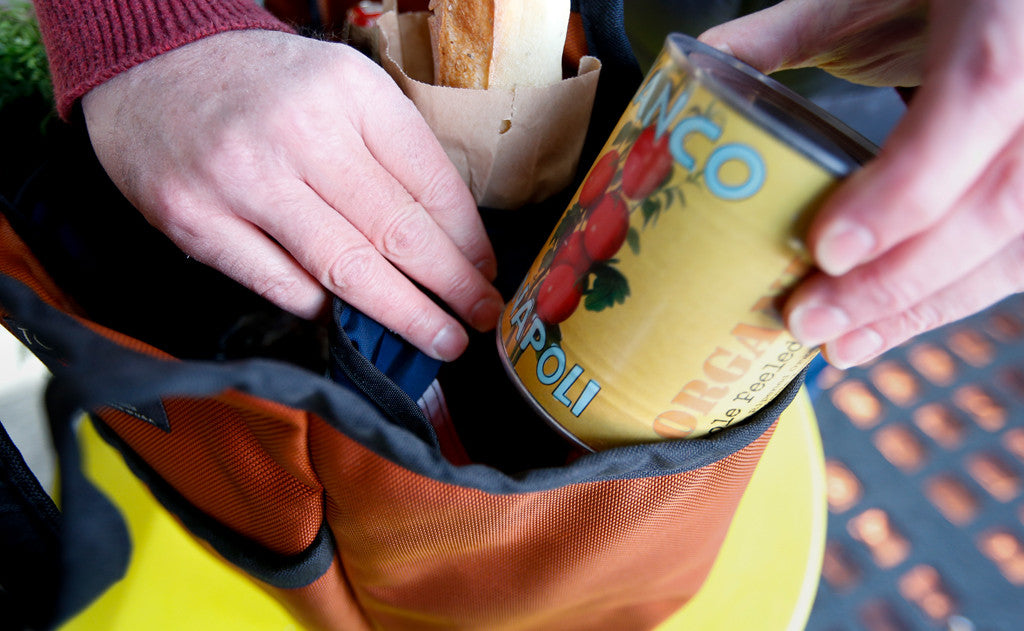 lifestyle visible^^A person placing a can of tomatoes in The Moveable Feast.