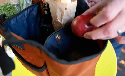 lifestyle visible^^A person placing a piece of fruit into the Moveable Feast.