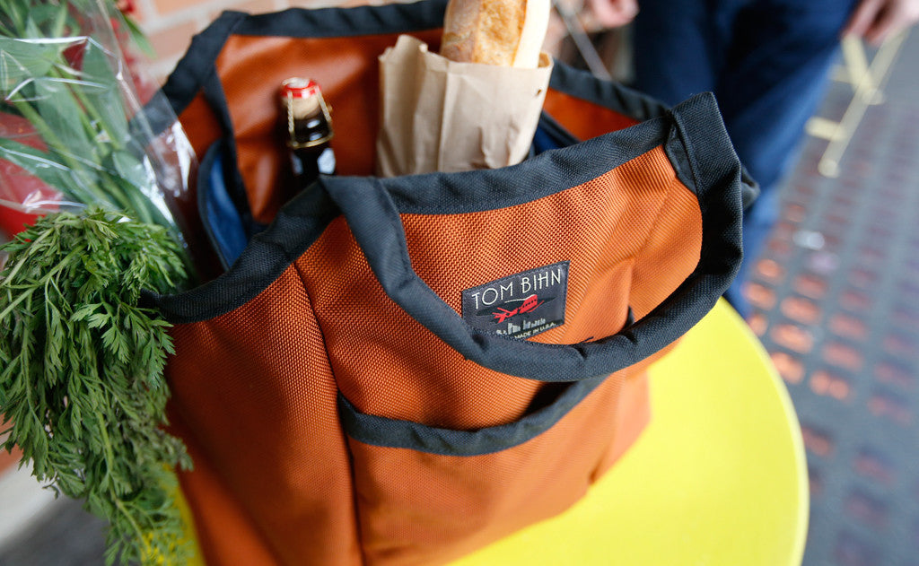 lifestyle visible^^A Moveable Feast holding a beer an a baguette.