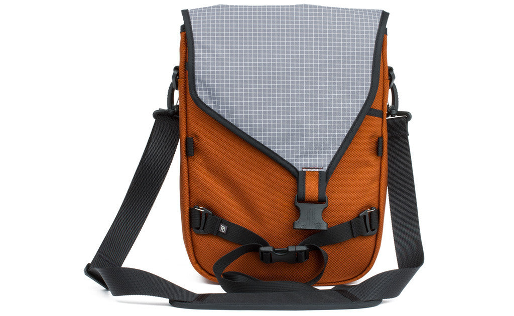 visible variant TB0243-TBND^^The Ristretto in Burnt Orange 1050 Ballistic with Northwest Sky (light grey with white grid) 200 Halcyon interior.