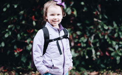 lifestyle visible^^A child wearing The Sprout with the sternum strap connected.
