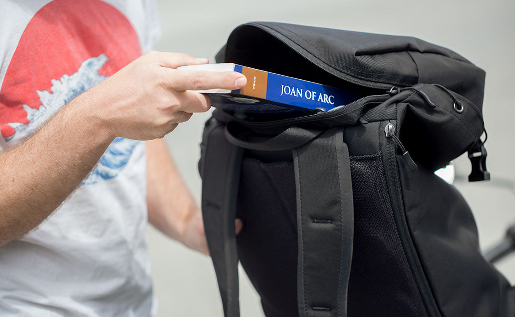 lifestyle visible^^Nik puts a copy of the book Joan of Arc by Mark Twain in the top pocket of the Shadow Guide. The zipper is on the back of the top pocket.
