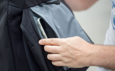 lifestyle visible^^Nik puts his cell phone in one of the side access zipper pockets on the bottom of the top pocket of the Shadow Guide.