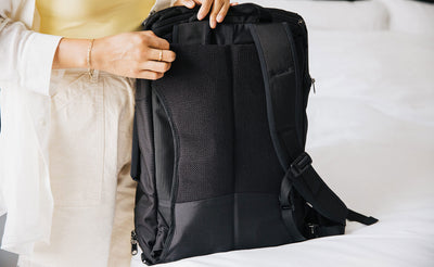 visible lifestyle ^^ A person removing the shoulder straps of the Techonaut 30, showing the mesh of the back panel.