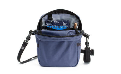 Travel Cubelet zipped open showing the interior open-top organizer pockets with small notebooks in the phone-sized pocket and a pen in the pen pocket.