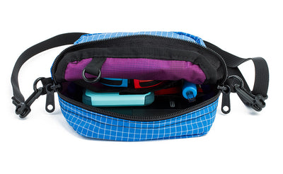 ^^Travel Cubelet zipped open showing the interior open-top organizer pockets with a phone in the larger pocket and a pen in the pen pocket.