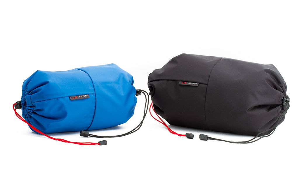 detail visible^^An Aeronaut 30 Travel Laundry Stuff Sack in Island (blue) 210 Ballistic next to an Aeronaut 45 Travel Laundry Stuff Sack in Black 210 Ballistic.