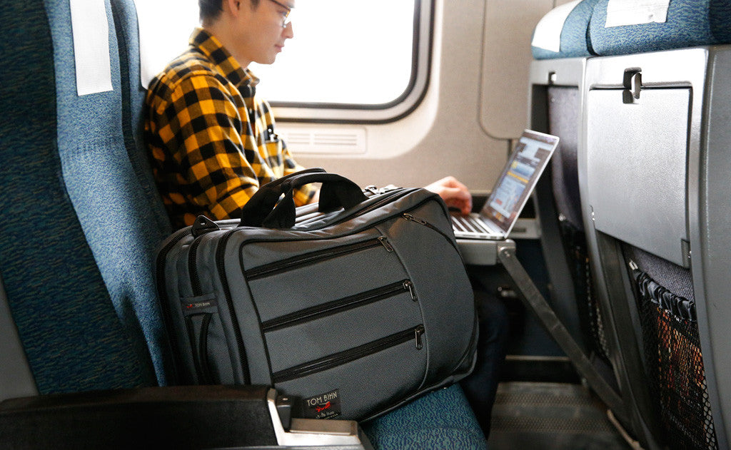 lifestyle visible^^A person using a laptop on a train with the Tri-Star in the next seat.