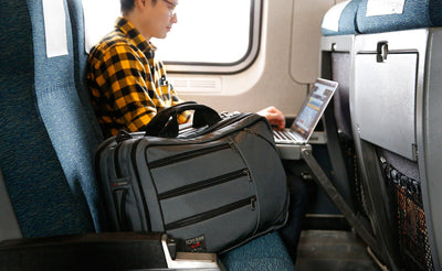 lifestyle visible^^A person using a laptop on a train with the Tri-Star in the next seat.