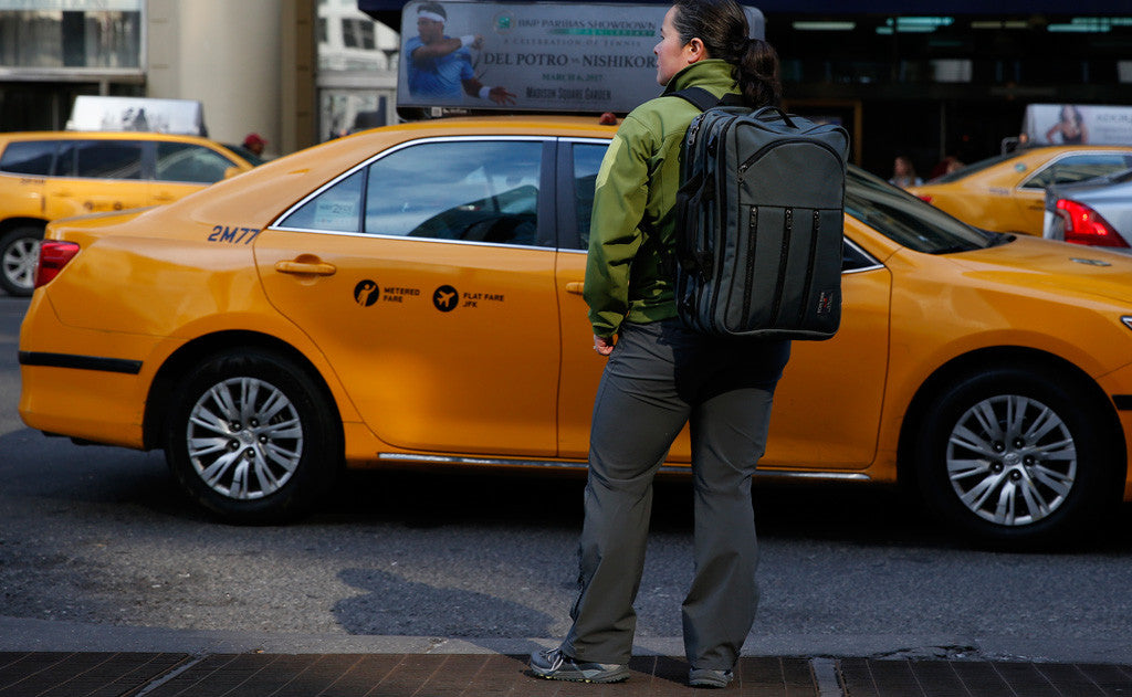 lifestyle visible^^A person hailing a cab while wearing a Tri-Star via the included backpack straps.