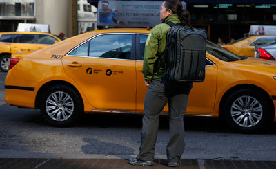 lifestyle visible^^A person hailing a cab while wearing a Tri-Star via the included backpack straps.