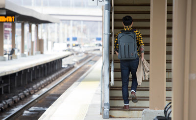 lifestyle visible^^A person walking on a rail station platform while wearing a Tri-Star via the included backpack straps.