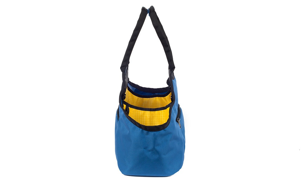 visible variant TB0619-NKOD^^The Truckasana in Constellation blue/Solaris yellow. Side view of the bag.