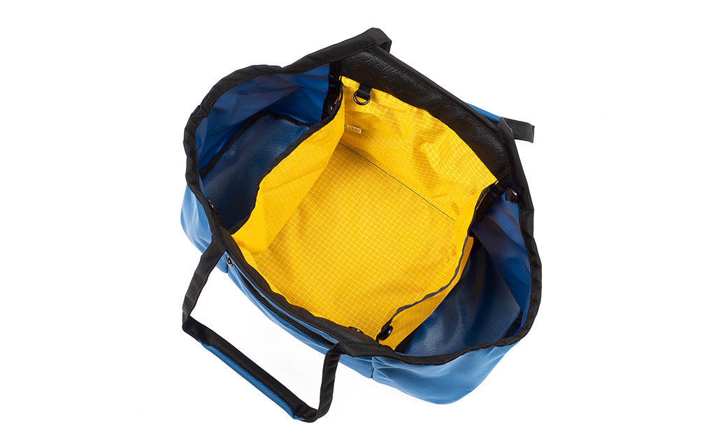 visible variant TB0619-NKOD^^The Truckasana in Constellation blue/Solaris yellow. Top-down view showing the three compartments of the empty bag.