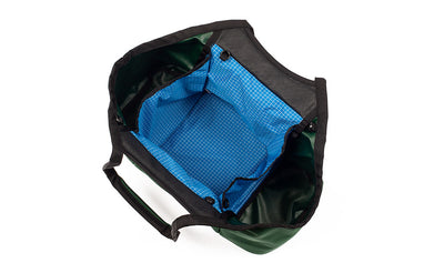 visible variant TB0619-WKLD^^The Truckasana in Wilderness green/Island blue. Top-down view shows the three main compartments of the bag empty.