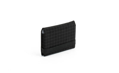 visible variant TB1277-BH^^The Size 1 Nik's Minimalist Wallet in Black (black with grey grid) 400 Halcyon closed with the attached elastic band.