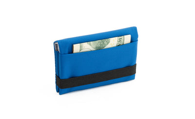 visible variant TB1275-IJ^^The Size 5 Nik's Minimalist Wallet in Island (blue) 210 Ballistic closed with the attached elastic band.
