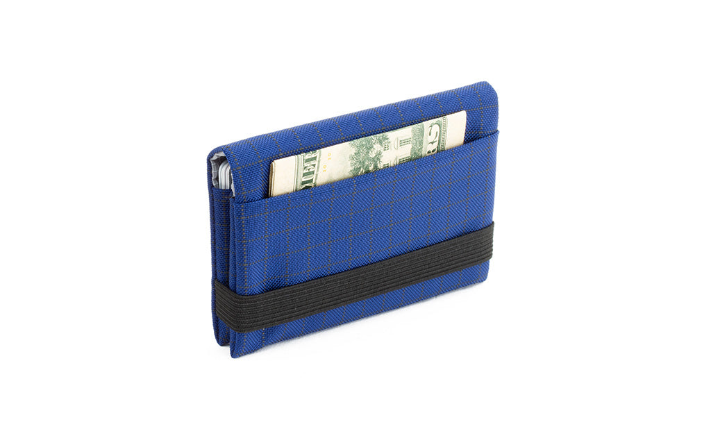 visible variant TB1275-DH^^The Size 5 Nik's Minimalist Wallet in Nordic (blue with grey grid) 400 Halcyon closed with the attached elastic band.