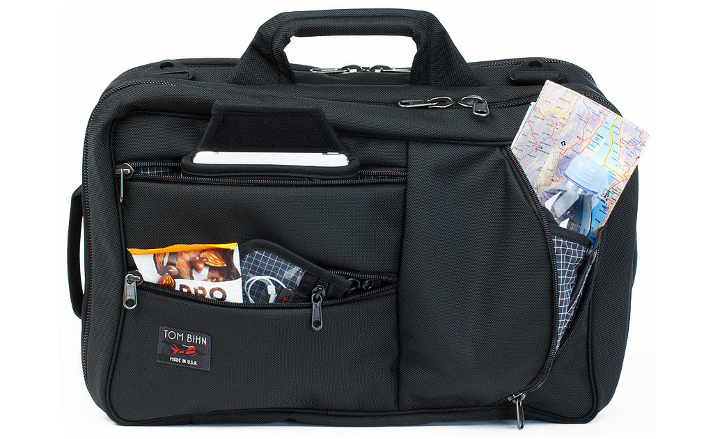 detail visible^^A front shot of the a Black 1050 Ballistic exterior Western Flyer with a map, tablet, snacks, and a pouch with cables in the front zippered pockets.