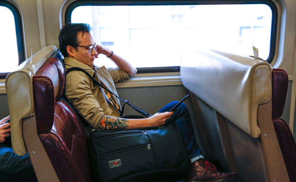 lifestyle visible^^A person sitting in a rail car seat with a Black 525 Ballistic Western Flyer in the seat beside them.