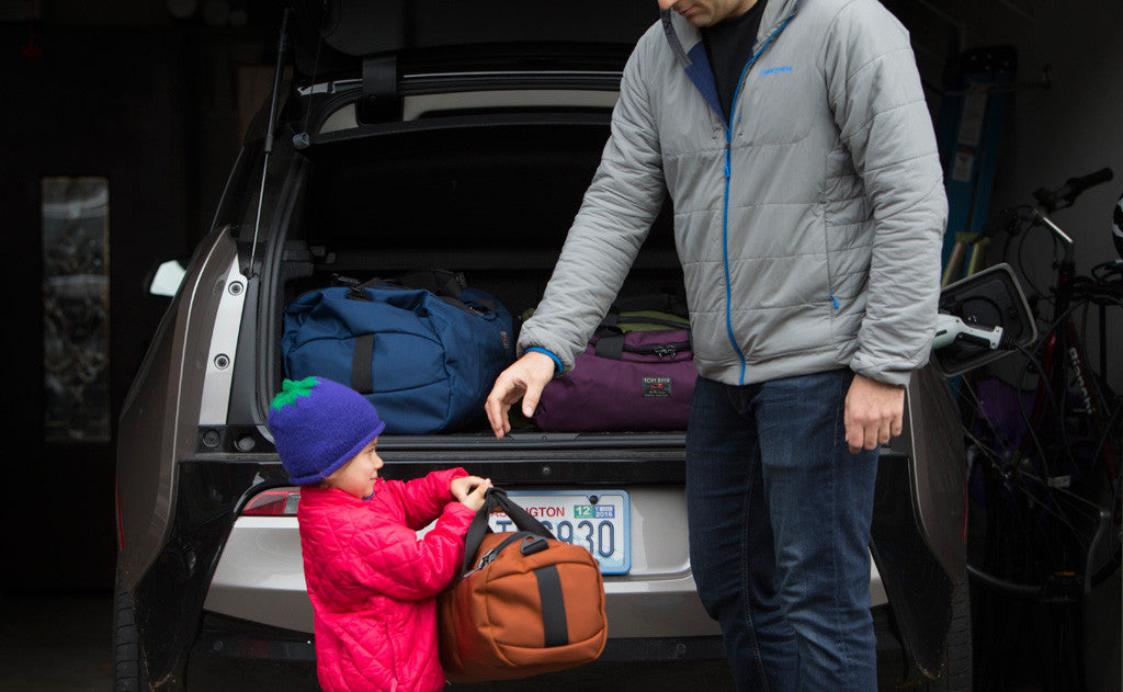 visible lifestyle ^^ A child handing a mini Yeoman to an adult to pack in a hatchback car.