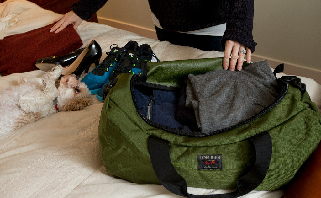 visible lifestyle ^^ A person packing clothes into the Medium Yeoman Duffel.