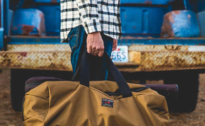 lifestyle visible ^^ A Yeoman Duffel being carried by its top grab handle.