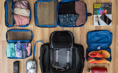 lifestyle visible^^An example of a typical Aeronaut 30 loadout is one Large Packing Cube, two Small Packing Cubes, a book, one End Pocket Packing Cube, a 3D Clear Organizer Cube, a reuseable water bottle, and eyeglasses.