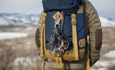 visible variant PT0574-IA PT0574-CA PT0574-BA PT0574-NA^^A large double carabiner connecting a pair of snow cleats to the lashpoint of a Guide's Pack.