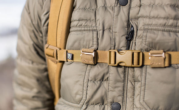 A Coyote (brown) Strap Keeper holding a sternum strap excess strap in place.
