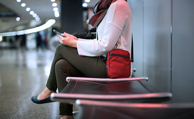 lifestyle visible^^Person sitting and reading their phone while wearing an Everyday Cubelet in the airport.