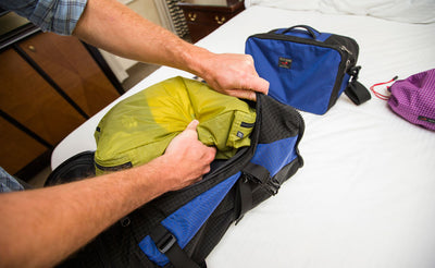 lifestyle visible^^A person putting a Hero's Journey Packing Cube into the Hero's Journey.