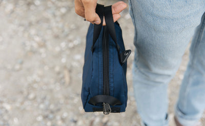 lifestyle visible^^ a Navy Parapack Grab Bag being held by it's grab handles. 