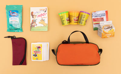 detail visible^^ a Texturized Orange Grab Bag with a child's toys and snacks next to it. 