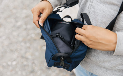 lifestyle visible^^ A person holding a Navy Parapack Grab Bag attached to a shoulder strap being held open. 