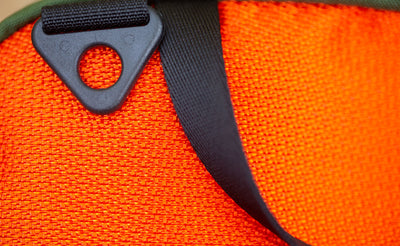 detail visible^^ A close up picture of a Texturized Orange Grab Bag showing the d-ring shoulder strap attachment and grab handle. 