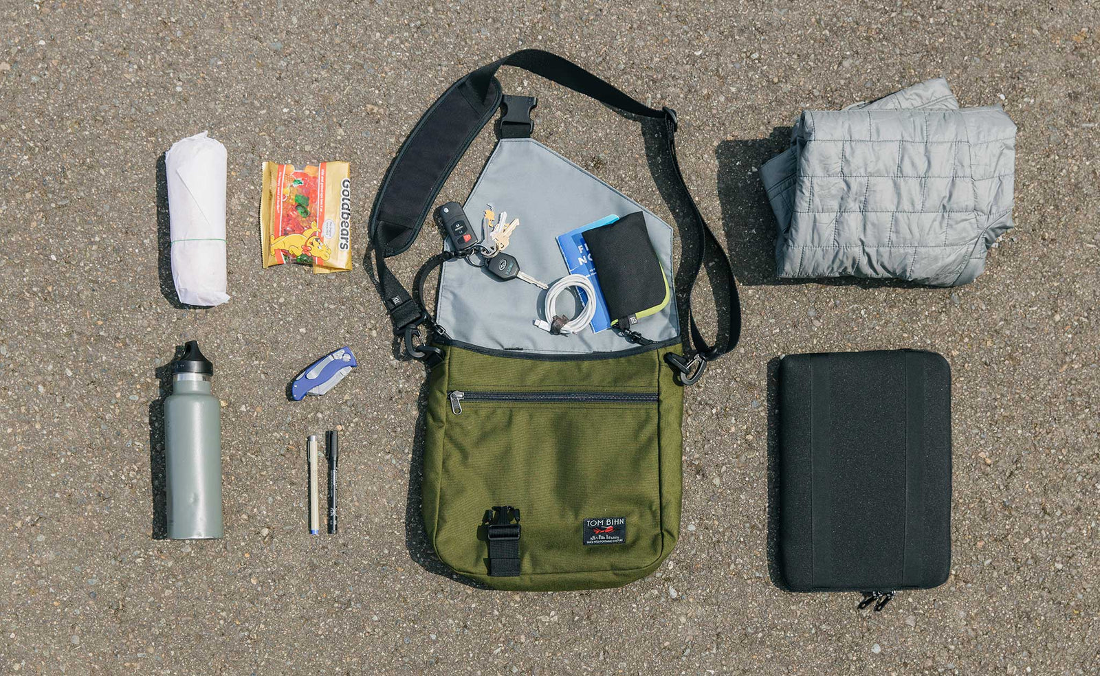 lifestyle visible^^An example of what can fit in the Large Cafe! Sandwich, gummy bears, water bottle, utility knife, pens, keys, wallet, notebook, Ghost Whale pouch, power cord, jacket, and iPad in a Cache.