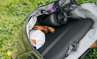 lifestyle visible^^Looking inside a Large Cafe Bag! There's a sandwich, water bottle, gummy bears, a tablet in a cache, a utility knife, power cord, and pens.