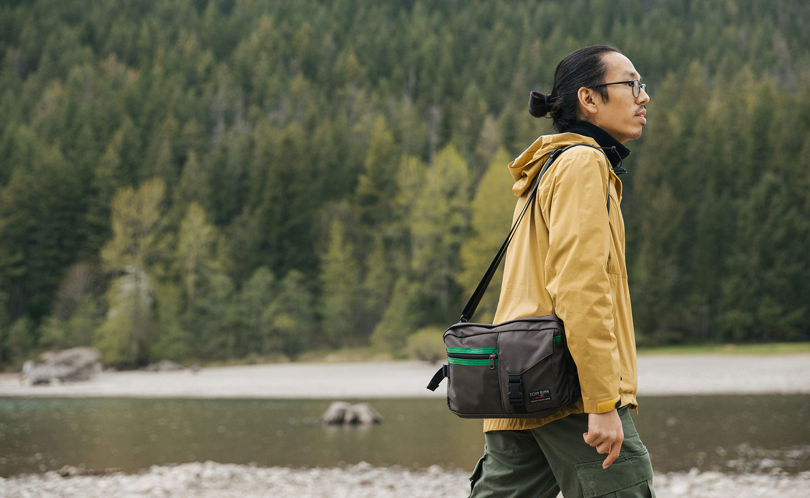 lifestyle visible^^Person walking next to a river, wearing the LGD as a shoulder carry bag.