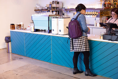 lifestyle visible^^A person carrying the Luminary 12 while ordering from a cafe.