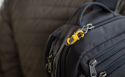 visible variant PT0573-OA PT0573-LA PT0573-UA^^A mini double carabiner clipping the zipper tabs of a Synik 30 together.