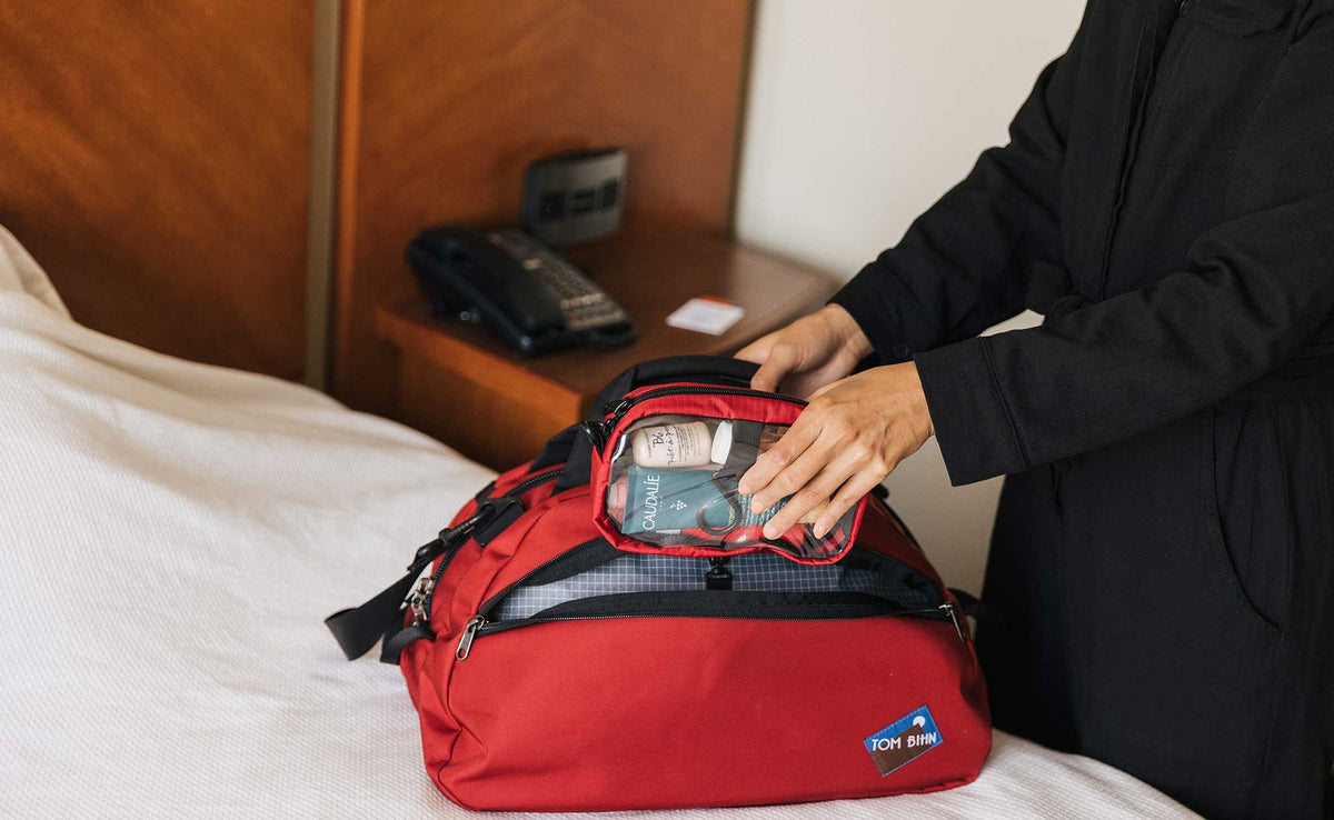 visible lifestyle^^Person pulling a 3D Clear Organizer Cube out of the side pocket of the OSCA.