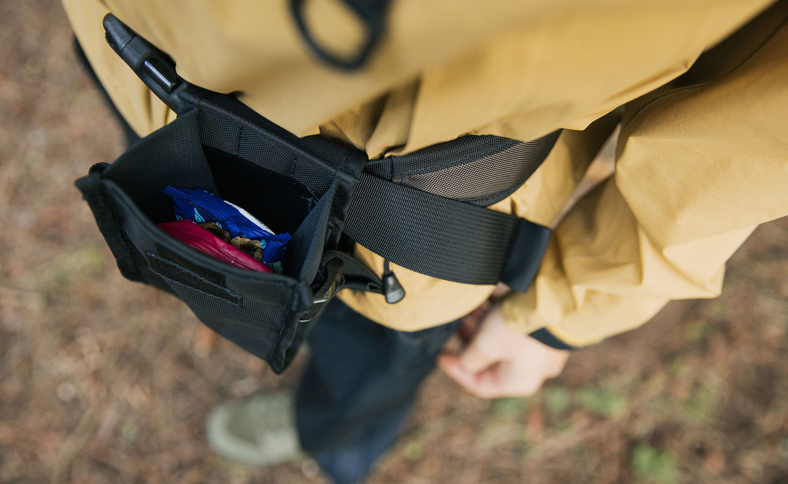 lifestyle visible^^Top-down photo of a Padded Hip Belt Pocket snapped open; snacks are inside.