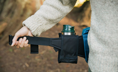 lifestyle visible^^Person holding one end of the unbuckled LGD waist strap to show how the Padded Hip Belt Pocket slides on the strap.